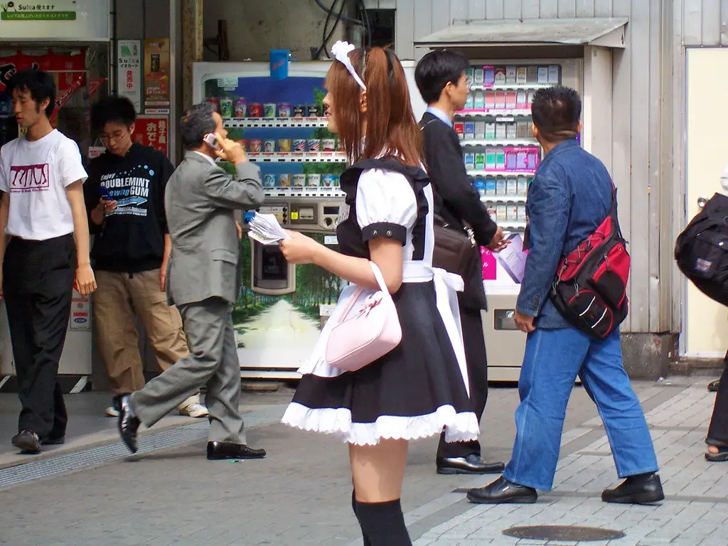 A young woman dressed as a maid, promoting a maid cafe